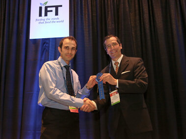 Ali while receiving the 1st place at IFT18 Student Research Paper Poster Competition.