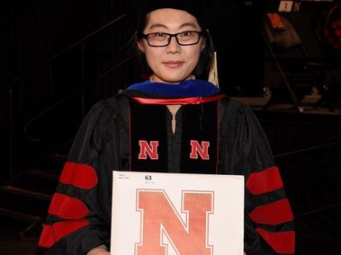 Lingyi holding her diploma at the graduation ceremony.