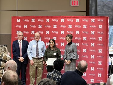 Purlen holding her Milton E. Mohr Fellowship certificate with Drs. Weller, Heng-Moss and Clutter