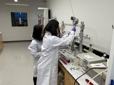 Lingyi and Yue working on the integrated supercritical carbon dioxide extraction-reaction system in the lab.